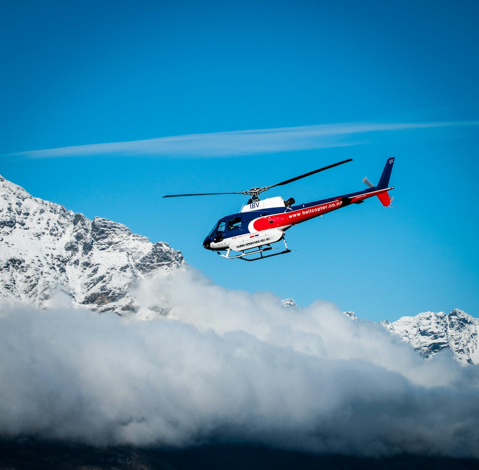 Helicopter flying over snow-capped mountains
